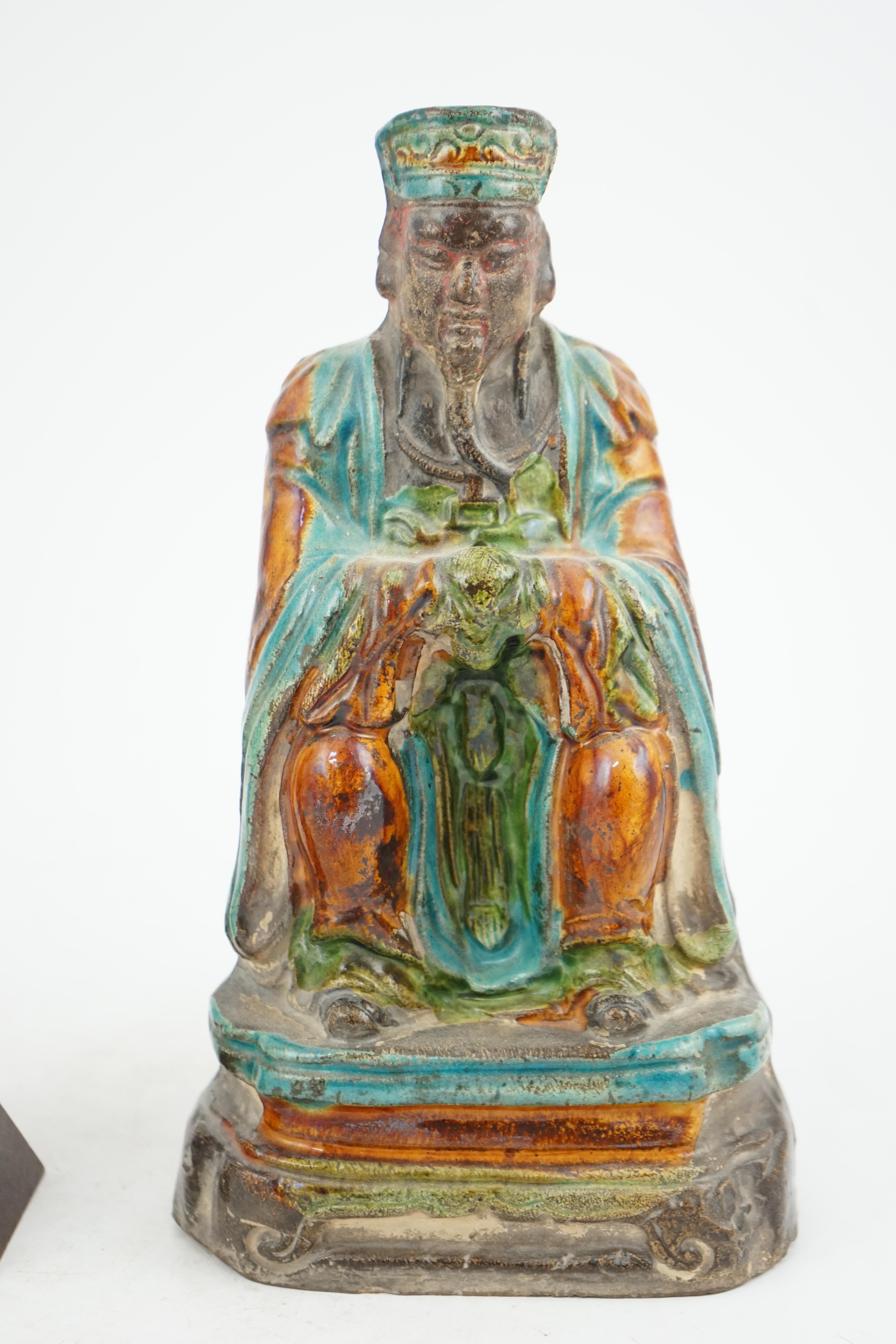 Two Chinese sancai glazed figures of a seated dignitary and a standing attendant, Ming dynasty